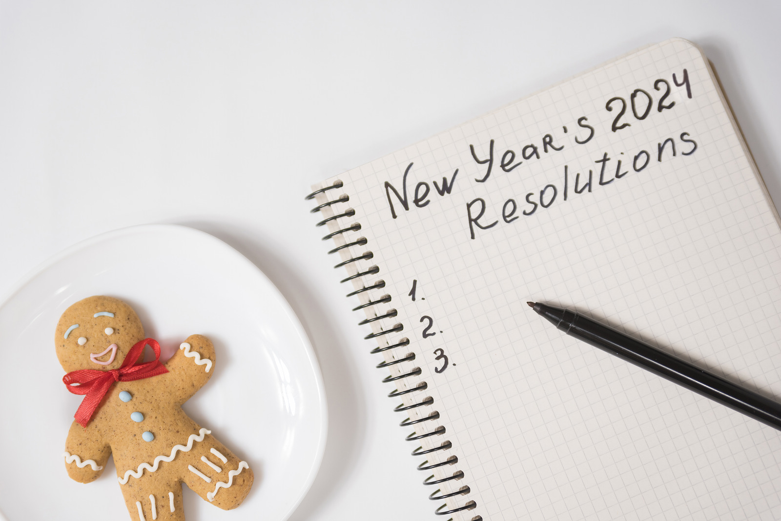 Phrase New Year's Resolutions 2024 In The Notebook And Pen. Gingerbread Man On Table