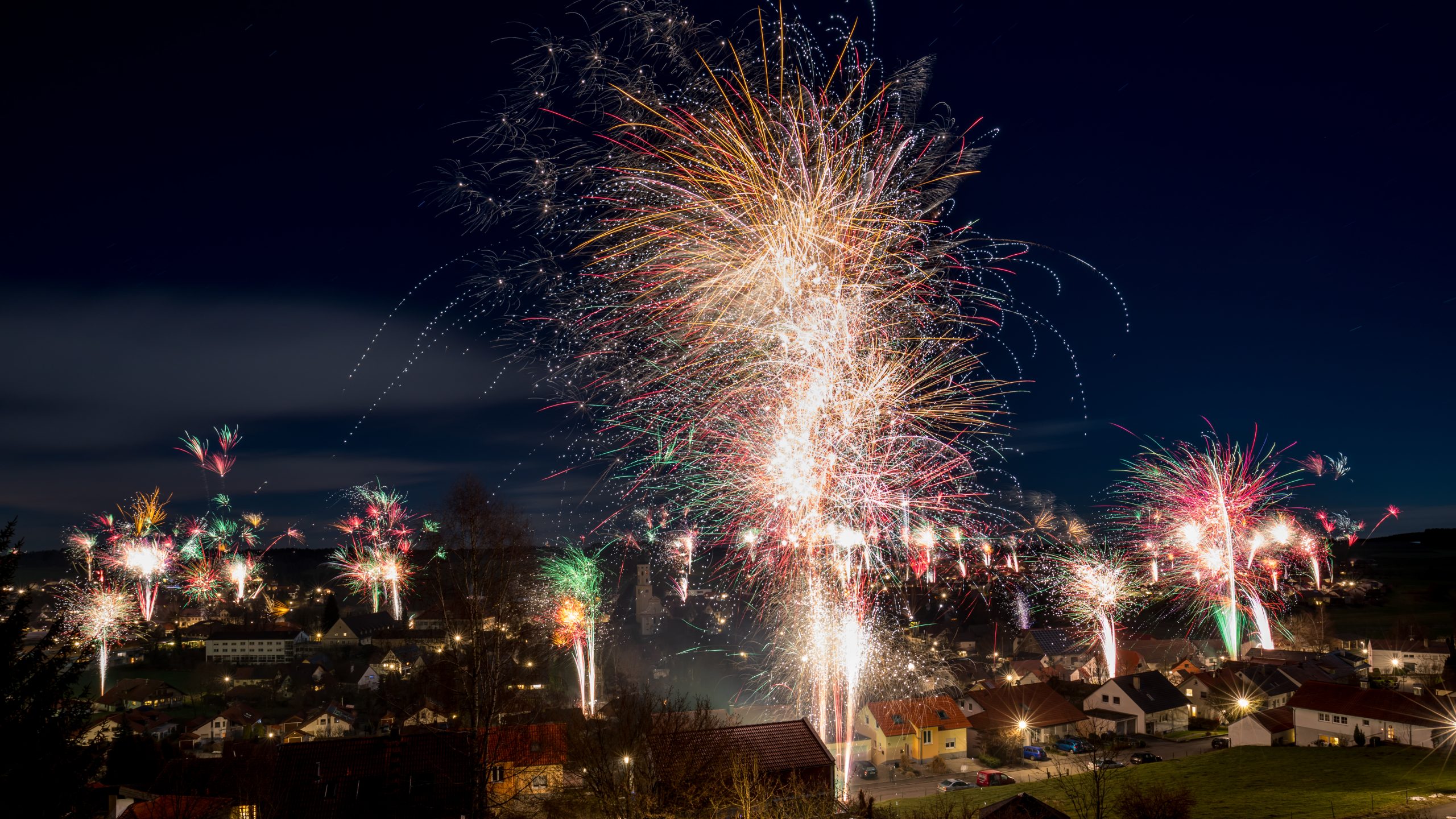 Huge New Year fireworks display lighting up the night sky above a village