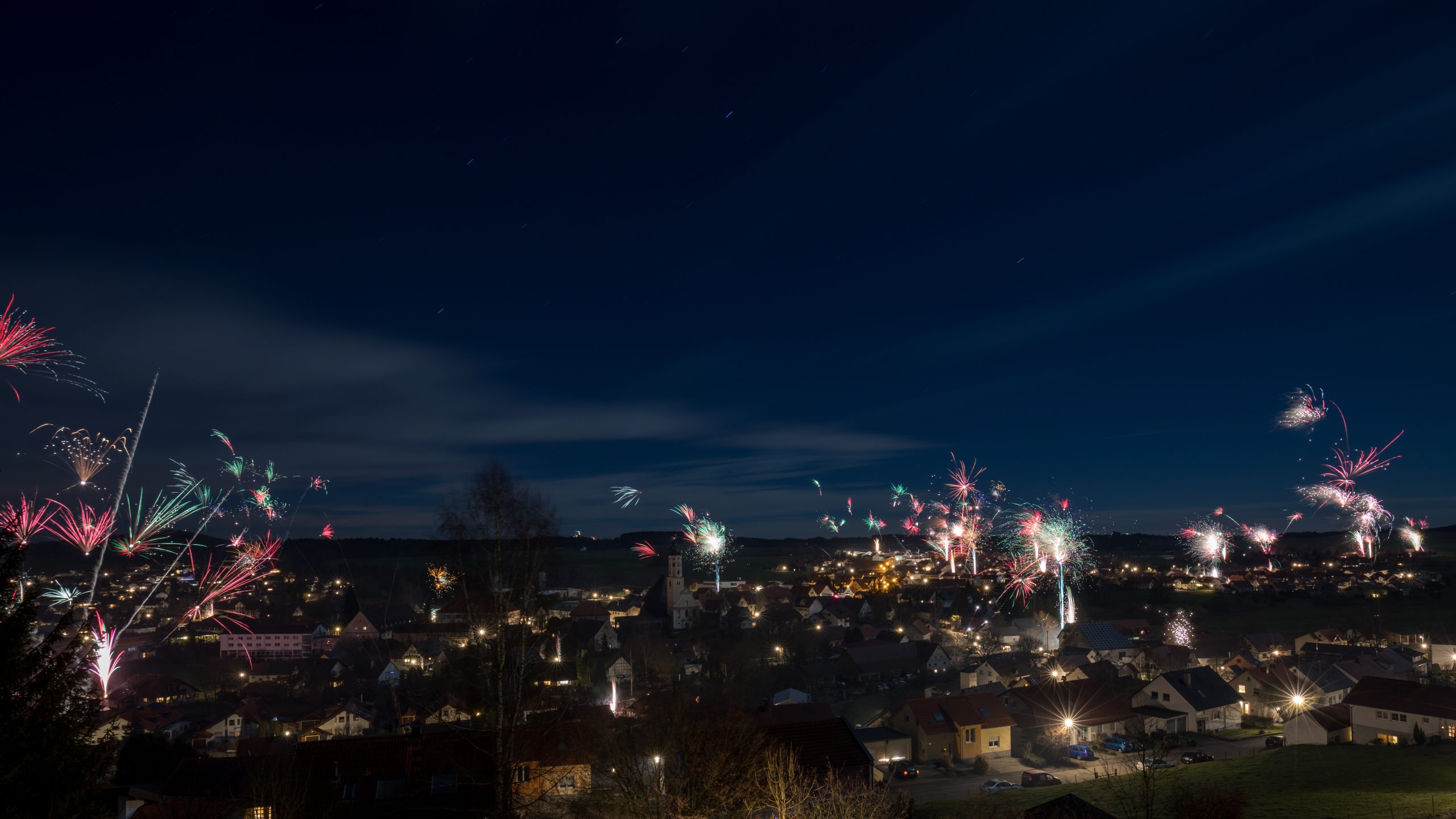 New Year fireworks bursting across a village skyline at night