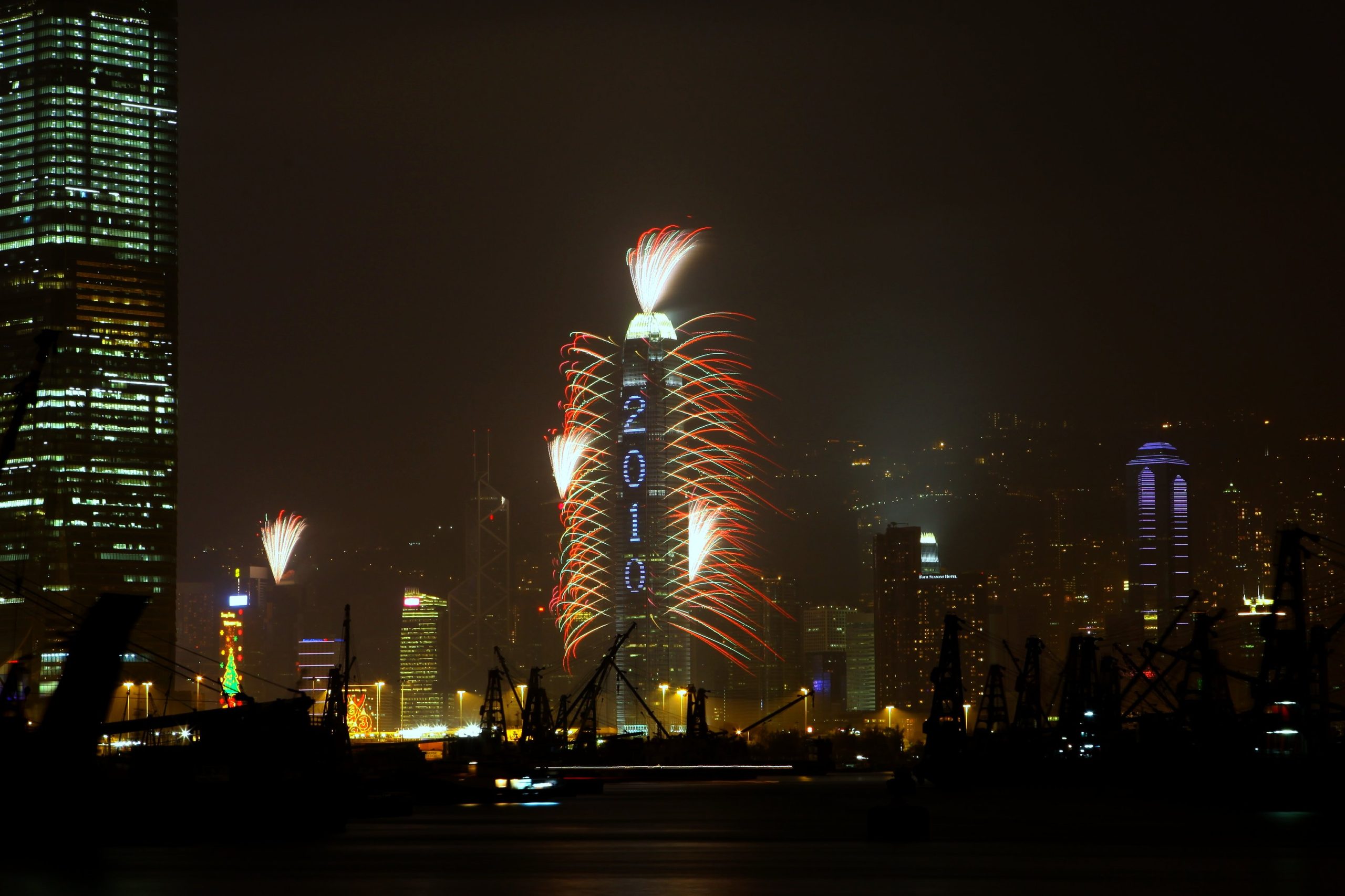 Red and white New Year fireworks bursting over the illuminated Hong Kong skyline at night