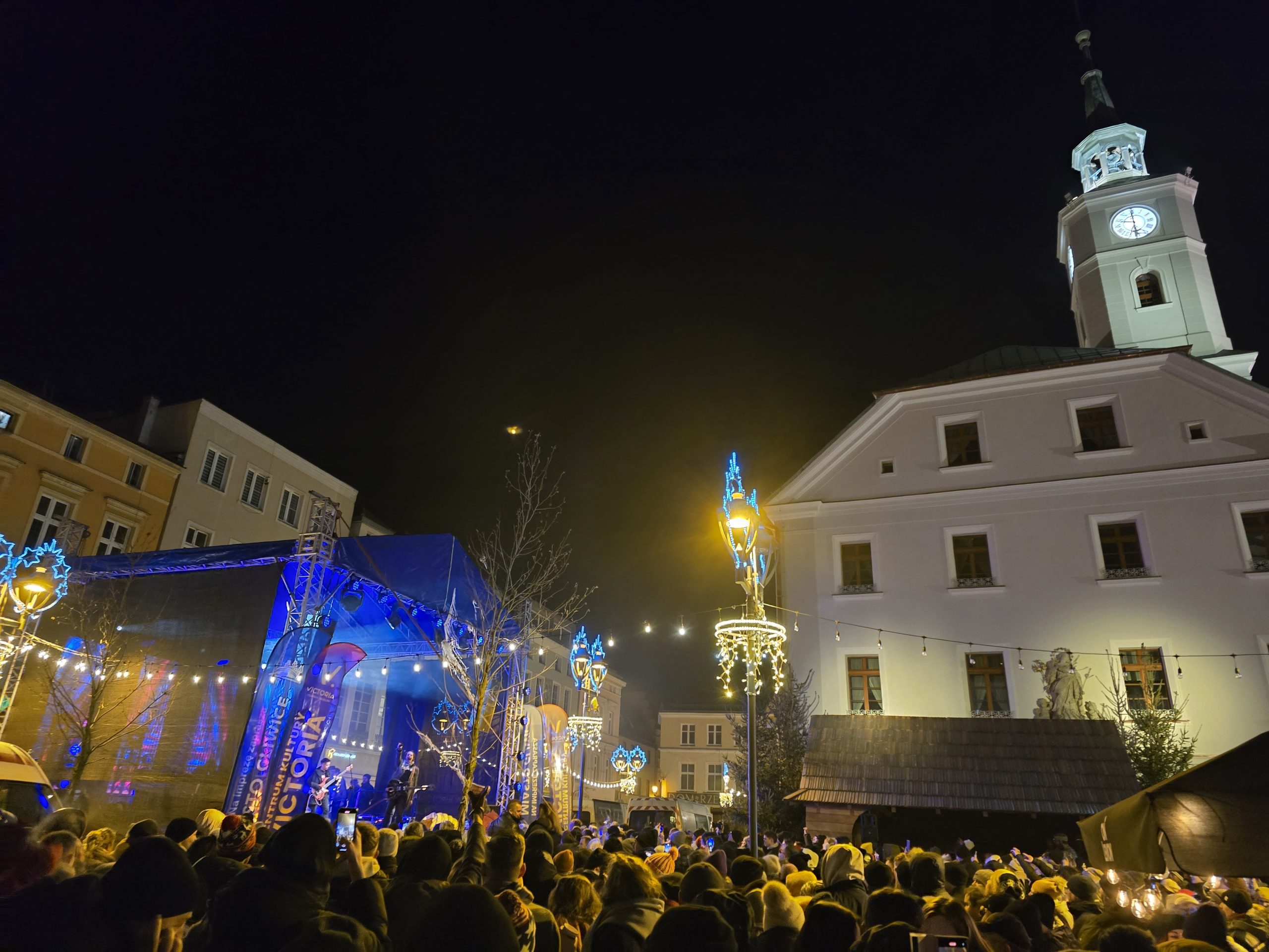 Crowd watching a live band on an outdoor stage at a New Year's Eve party