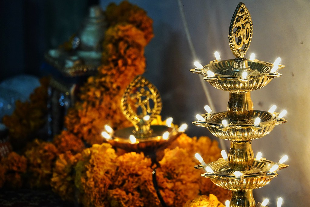 A Lakshmi Puja altar set up for Diwali with a diya, flowers and offerings
