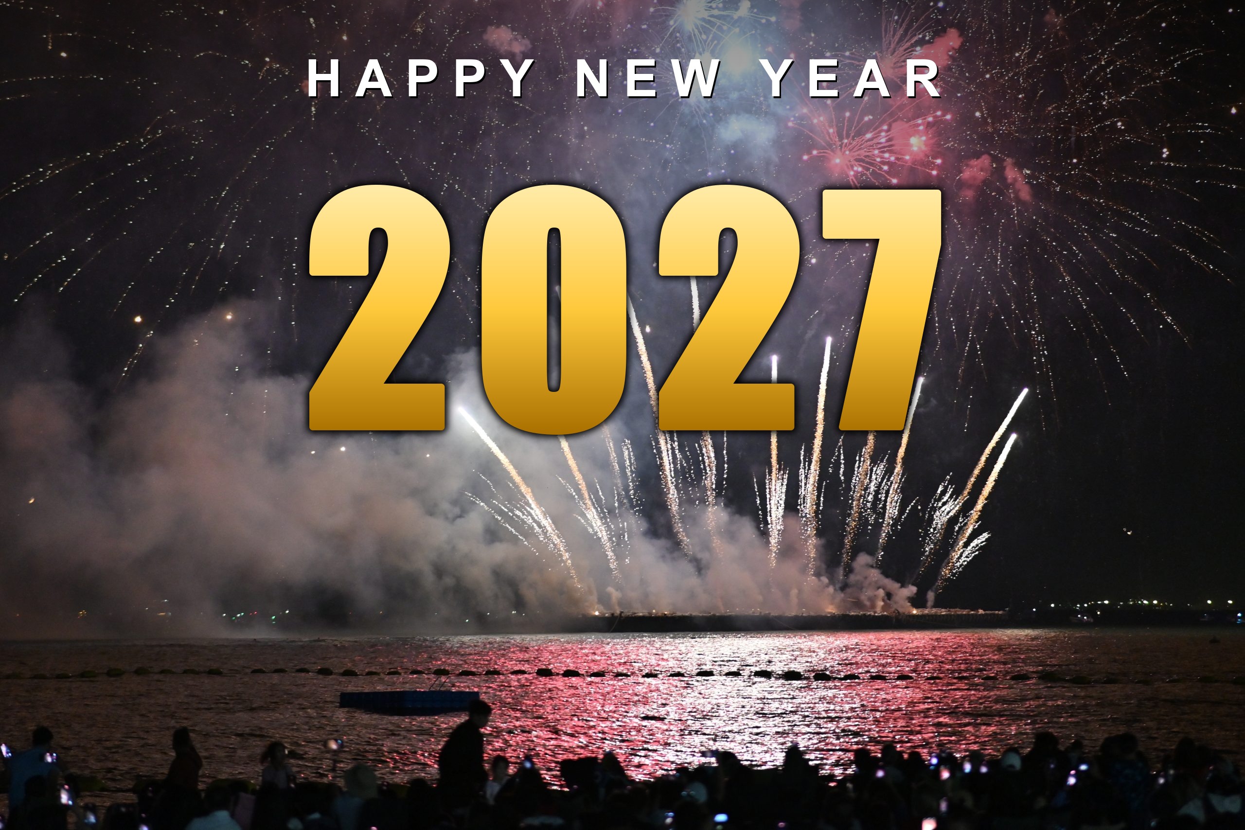 Happy New Year 2027 in gold lettering over colourful fireworks on water
