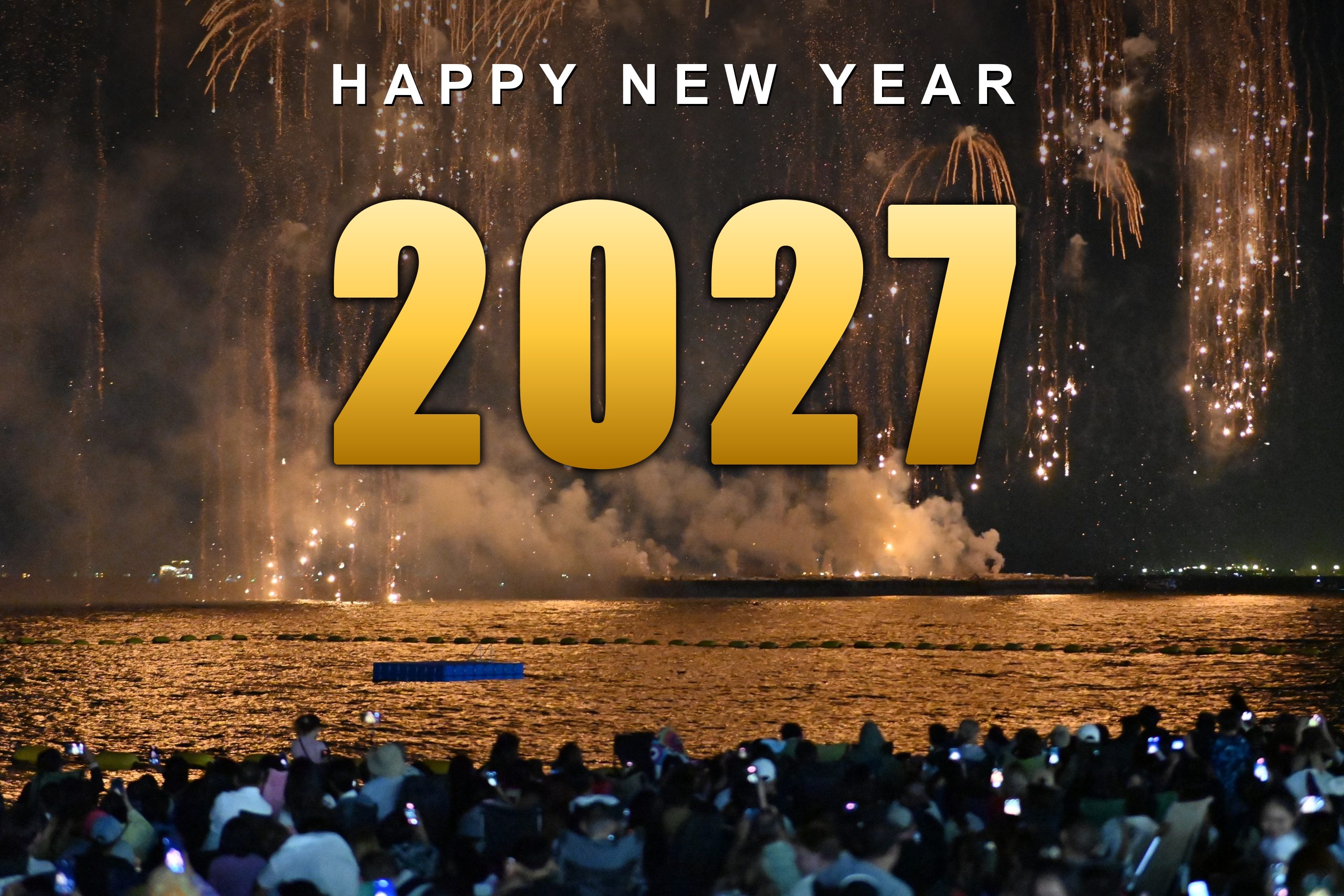 Happy New Year 2027 in gold lettering over golden fireworks on water